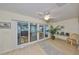 Bright living room featuring sliding glass doors, light wood floors, and a ceiling fan at 1912 Acadia Greens Dr, Sun City Center, FL 33573