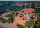 Stunning waterfront home with red tile roof, lush landscaping, and private dock access to the bay at 199 21St Ave, St Pete Beach, FL 33706