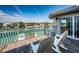 A serene waterfront balcony with seating overlooks a picturesque waterway and coastal landscape on a sunny day at 199 21St Ave, St Pete Beach, FL 33706