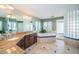 A luxurious Primary bathroom with a glass block shower, a tub with tile surround, and a spacious vanity at 199 21St Ave, St Pete Beach, FL 33706