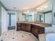 Spacious Primary bathroom with a double sink vanity, granite countertops, tile floors, and a glass block shower at 199 21St Ave, St Pete Beach, FL 33706