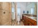 Well-lit bathroom featuring a walk-in shower with tiled walls and a vanity with a granite countertop at 199 21St Ave, St Pete Beach, FL 33706