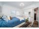 Charming bedroom with a cozy blue bed, soft lighting, and a white-painted closet at 199 21St Ave, St Pete Beach, FL 33706