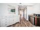 Bright hallway featuring wood floors, kitchenette, and a large mirror reflecting a television in a tastefully decorated home at 199 21St Ave, St Pete Beach, FL 33706