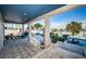 Covered patio with tile flooring, spiral staircase, and comfortable seating overlooking the serene waterfront at 199 21St Ave, St Pete Beach, FL 33706