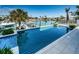 Backyard featuring a stunning infinity pool, beautiful landscaping, and a waterfront view with boat docks at 199 21St Ave, St Pete Beach, FL 33706