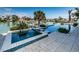 Backyard featuring a jacuzzi, stunning infinity pool, beautiful landscaping, and a waterfront view at 199 21St Ave, St Pete Beach, FL 33706