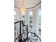 Bright foyer staircase featuring large arched windows, wood railings, and a crystal chandelier at 199 21St Ave, St Pete Beach, FL 33706