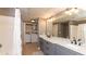 Bathroom featuring a double vanity, marble countertops, and a shower with tub and open closet at 2010 E Palm Ave # 14206, Tampa, FL 33605