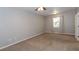 A spacious bedroom is showcased with a ceiling fan, window, and neutral carpet at 2010 E Palm Ave # 14206, Tampa, FL 33605