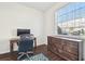 Well-lit office featuring a dark-wood desk, dresser, and a large window overlooking the yard at 2044 Greenwood Valley Dr, Plant City, FL 33563