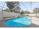 Beautiful kidney-shaped pool with screen enclosure, waterfall feature, and surrounding patio at 2851 16Th N Ave, St Petersburg, FL 33713
