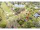Aerial view of home nestled among lush greenery overlooking a golf course at 29318 Whipporwill Ln, Wesley Chapel, FL 33543