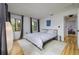 Comfortable bedroom features hardwood floors, a bed with gray bedding, and ample natural light at 29318 Whipporwill Ln, Wesley Chapel, FL 33543