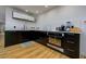 Modern kitchen featuring wood floors, stainless steel appliances, and a clean design at 29318 Whipporwill Ln, Wesley Chapel, FL 33543