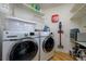 Well-organized laundry room with modern washer and dryer, shelving, and ample storage space at 29318 Whipporwill Ln, Wesley Chapel, FL 33543