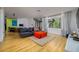 Spacious living room with wood floors, large windows, modern lighting, and bright color accents at 29318 Whipporwill Ln, Wesley Chapel, FL 33543