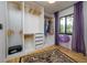 Well-organized walk-in closet with built-in shelving, storage drawers, and a statement purple chair at 29318 Whipporwill Ln, Wesley Chapel, FL 33543