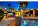 Night view of the pool and backyard with a waterfall feature, hot tub, hammock, and ambient lighting at 5004 Paloma Dr, Tampa, FL 33624