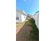 Narrow side yard features a strip of grass and a white fence, adding privacy to the property at 602 Danube Ave, Tampa, FL 33606