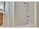 Modern bathroom features a jetted tub, showerhead, and white tiled backsplash with grab bars for safety at 603 S Sylvan Dr, Brandon, FL 33510