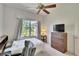 Cozy bedroom features a dresser, ceiling fan, and lots of light from the exterior views offered by the window at 603 S Sylvan Dr, Brandon, FL 33510