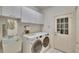 Bright laundry room with sink, built-in storage and modern washer and dryer at 603 S Sylvan Dr, Brandon, FL 33510