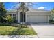 Inviting single-Gathering home featuring a manicured lawn, mature landscaping, and a two-car garage at 6539 Salt Creek Ave, Apollo Beach, FL 33572