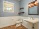 Charming bathroom featuring a pedestal sink, wainscoting, and rustic light fixture at 6615 Ridge Top Dr, Trinity, FL 34655