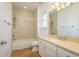 Bright bathroom featuring a tiled shower/tub combo, a vanity with a tan countertop, and a window at 6615 Ridge Top Dr, Trinity, FL 34655