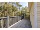 This home has a spacious wooden deck with railing, overlooking the yard with mature trees at 6615 Ridge Top Dr, Trinity, FL 34655