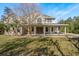 Charming two-story home with a covered porch and a lush, green lawn on a sunny day at 6615 Ridge Top Dr, Trinity, FL 34655