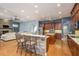Open concept kitchen features a stone-clad breakfast bar overlooking the living room at 6615 Ridge Top Dr, Trinity, FL 34655