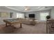 Spacious living room featuring a pool table, comfortable seating, and modern decor at 6615 Ridge Top Dr, Trinity, FL 34655