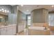 This main bathroom has double sinks, a soaking tub, and glass block window at 6615 Ridge Top Dr, Trinity, FL 34655