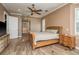 A cozy main bedroom with a ceiling fan, hardwood floors, and ensuite bath at 6615 Ridge Top Dr, Trinity, FL 34655