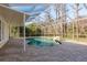 Backyard pool with a screen enclosure, stone feature, and brick paver deck at 6615 Ridge Top Dr, Trinity, FL 34655