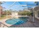 Screened-in pool area showcasing a kidney-shaped pool, patio space, and a view of the backyard at 6615 Ridge Top Dr, Trinity, FL 34655