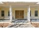 Inviting covered porch featuring double doors, ample seating, and views of the front yard at 6615 Ridge Top Dr, Trinity, FL 34655