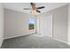 A bright, carpeted bedroom with a ceiling fan and a closet, offering natural light and storage space at 7086 Chatum Light Run, Bradenton, FL 34212