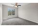 A bright, empty bedroom featuring a ceiling fan and a large window offering natural light at 7086 Chatum Light Run, Bradenton, FL 34212