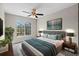 A cozy bedroom with a ceiling fan and a large window overlooking greenery, exuding a calming ambiance at 7086 Chatum Light Run, Bradenton, FL 34212