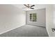 Bright bedroom showcasing a large window with pleasant outdoor views and neutral carpeting at 7086 Chatum Light Run, Bradenton, FL 34212