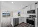 Modern kitchen with white cabinets, stainless steel appliances, and breakfast bar at 7086 Chatum Light Run, Bradenton, FL 34212