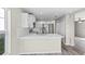 Bright kitchen featuring white cabinets, stainless appliances, and wood-look flooring at 7086 Chatum Light Run, Bradenton, FL 34212