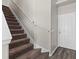 Carpeted staircase leading to the upper level, complemented by a crisp white door and neutral decor at 7086 Chatum Light Run, Bradenton, FL 34212