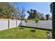 A well maintained backyard featuring lush green grass, mature trees, and a privacy fence at 906 S Sterling Ave, Tampa, FL 33629