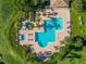 Aerial view of community pool and hot tub with palm trees, greenery, and chairs for lounging in the sun at 10263 Gandy N Blvd # 105, St Petersburg, FL 33702