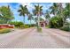 A brick entrance to the community surrounded by palm trees with a guard house in the distance at 10263 Gandy N Blvd # 105, St Petersburg, FL 33702