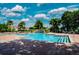 Community pool with brick pavers has multiple seating areas and a rock waterfall feature under a bright blue sky at 10263 Gandy N Blvd # 105, St Petersburg, FL 33702